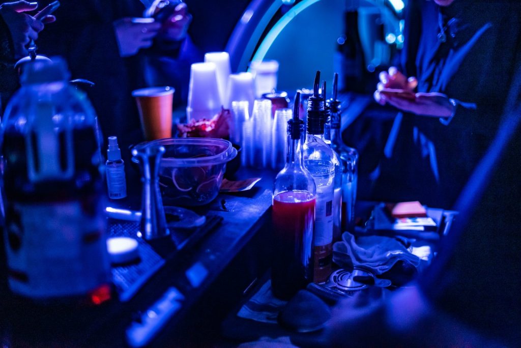 a group of people standing around a table filled with bottles